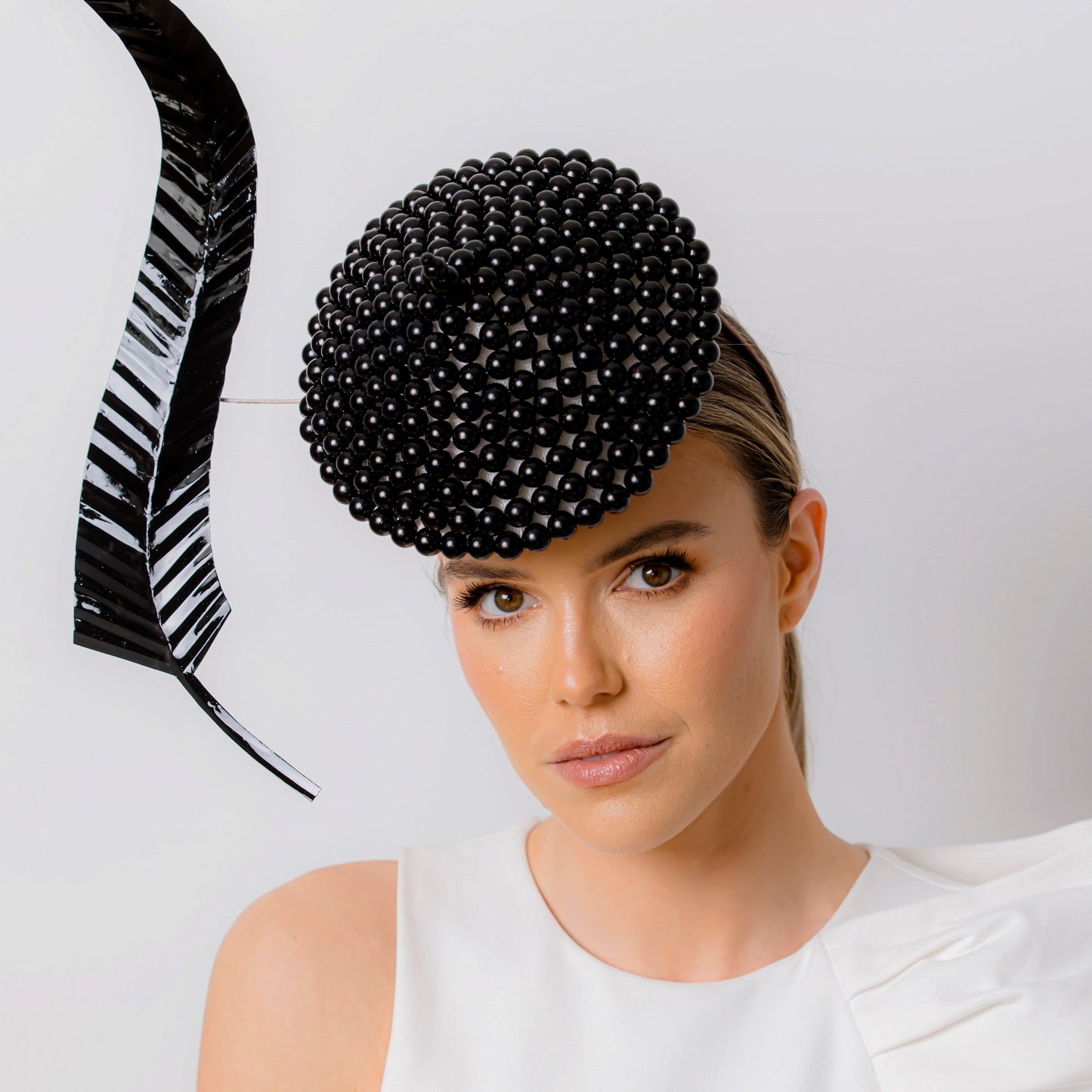 Woman wearing a black beaded hat against a white background