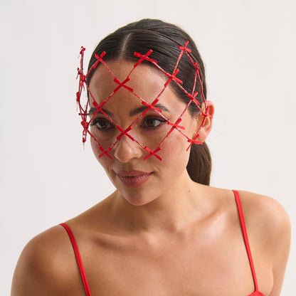 Woman wearing a red dress with a red face mask on a white background