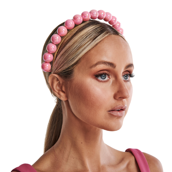 Woman wearing a pink beaded headband on a white background