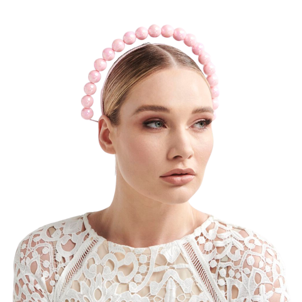 Woman wearing a pink beaded headband on a white background